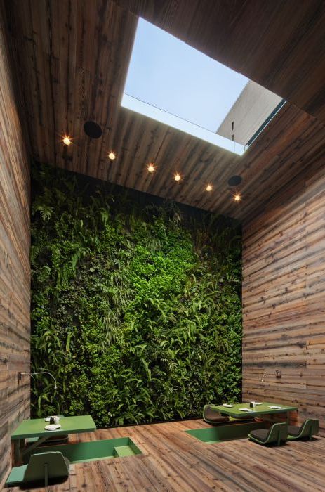 De groene tafel en de bloemrijke muur zorgen voor een ontzettend ontspannen sfeer.