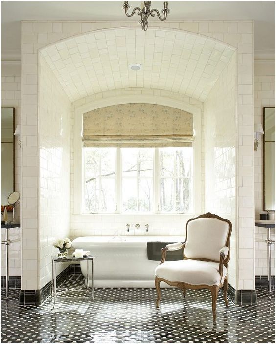 Een heerlijke lichte badkamer met witte tegels en een enorm raam.