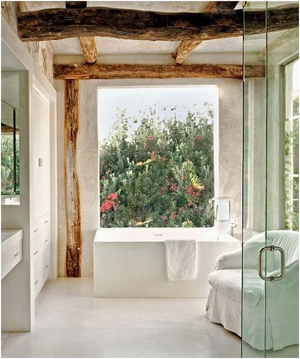 Grote badkamer met zichtbare houten balken en een prachtig uitzicht.